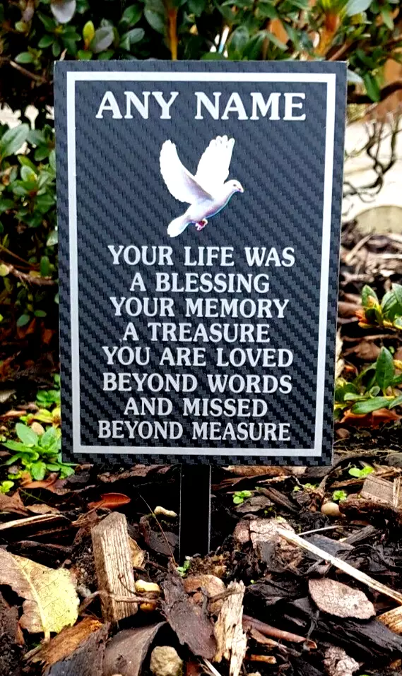 Rectangular memorial plaque with remembrance lettering and a ground stake.