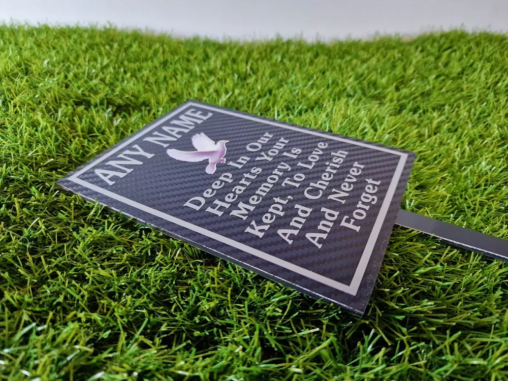 Rectangular memorial plaque with remembrance lettering and a ground stake.