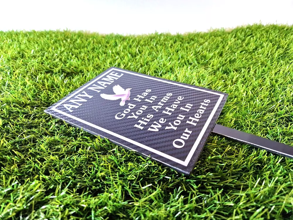 Rectangular memorial plaque with remembrance lettering and a ground stake.