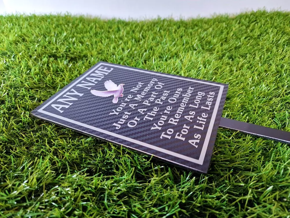 Rectangular memorial plaque with remembrance lettering and a ground stake.