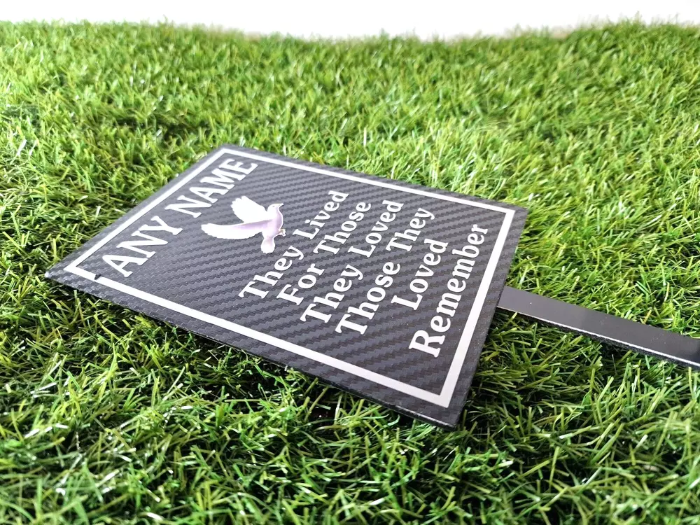 Rectangular memorial plaque with remembrance lettering and a ground stake.