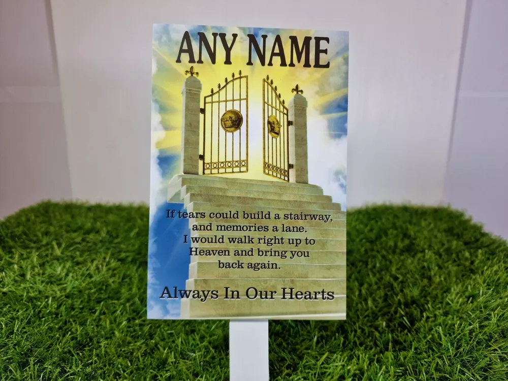 Rectangular memorial plaque with a golden gates and blue sky design and a ground stake.