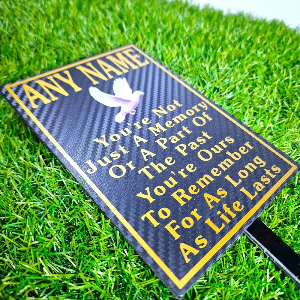 Rectangular memorial plaque with remembrance lettering and a ground stake.