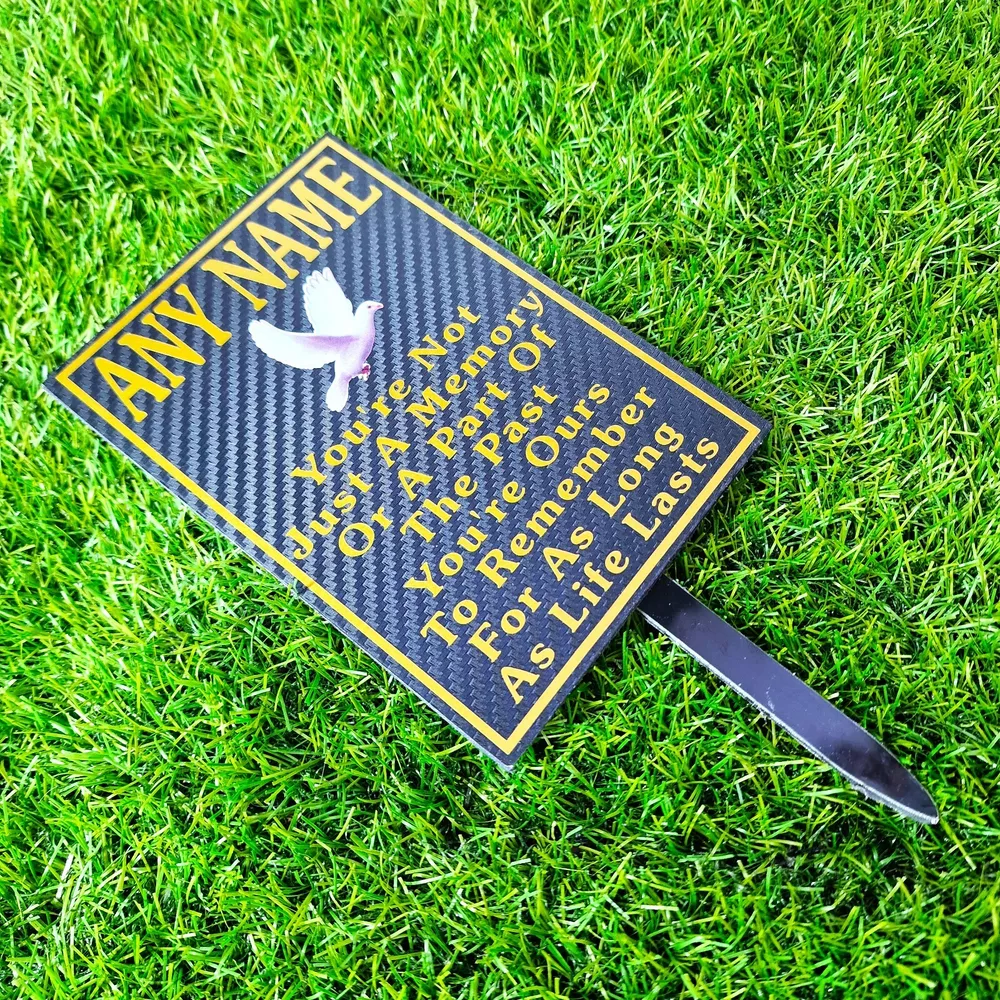Rectangular memorial plaque with remembrance lettering and a ground stake.