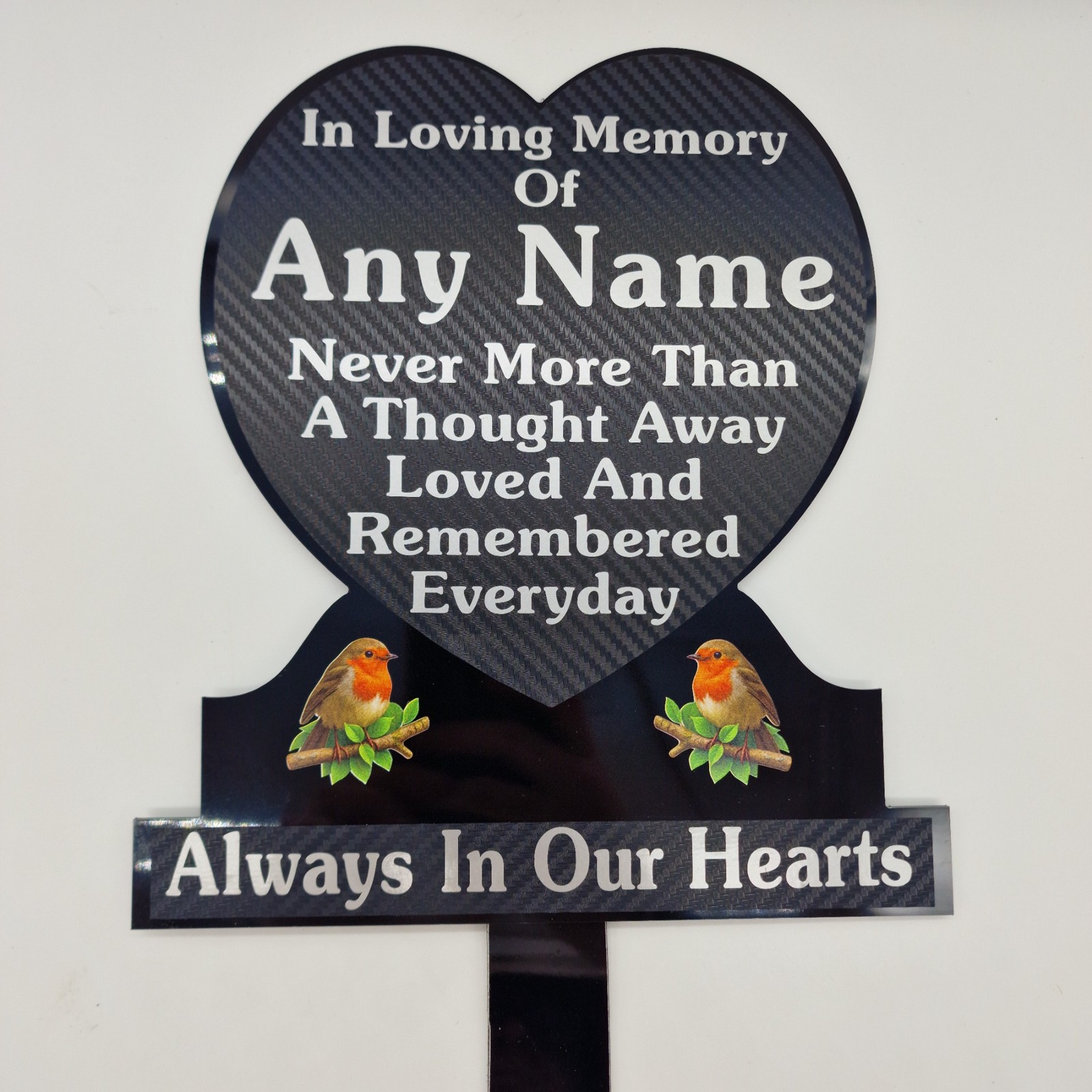 Black heart-shaped memorial plaque with silver name and remembrance lettering, two robin illustrations and a ground stake.
